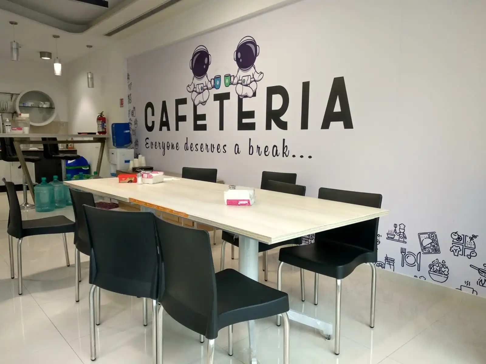 An office cafeteria with a wall message saying everyone deserves a break